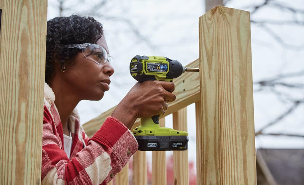 A woman attaches a handrail. A woman attaches a handrail.