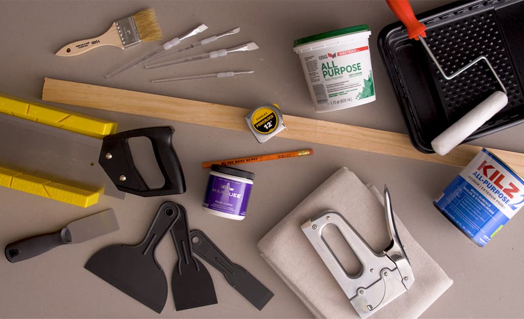 Miter box, staple gun and other supplies lay on a table. Miter box, staple gun and other supplies lay on a table.