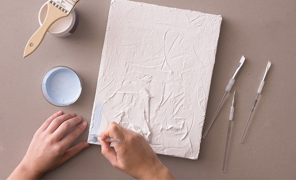 A light blue paint is applied to a canvas. A light blue paint is applied to a canvas.
