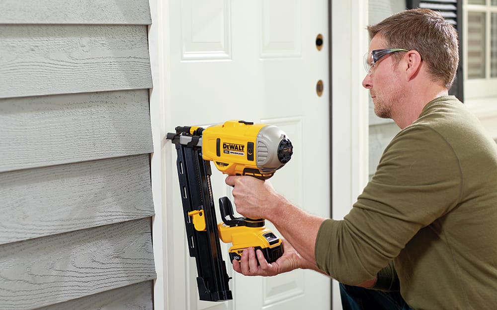A man securing a new entry door outside the home. A man securing a new entry door outside the home.
