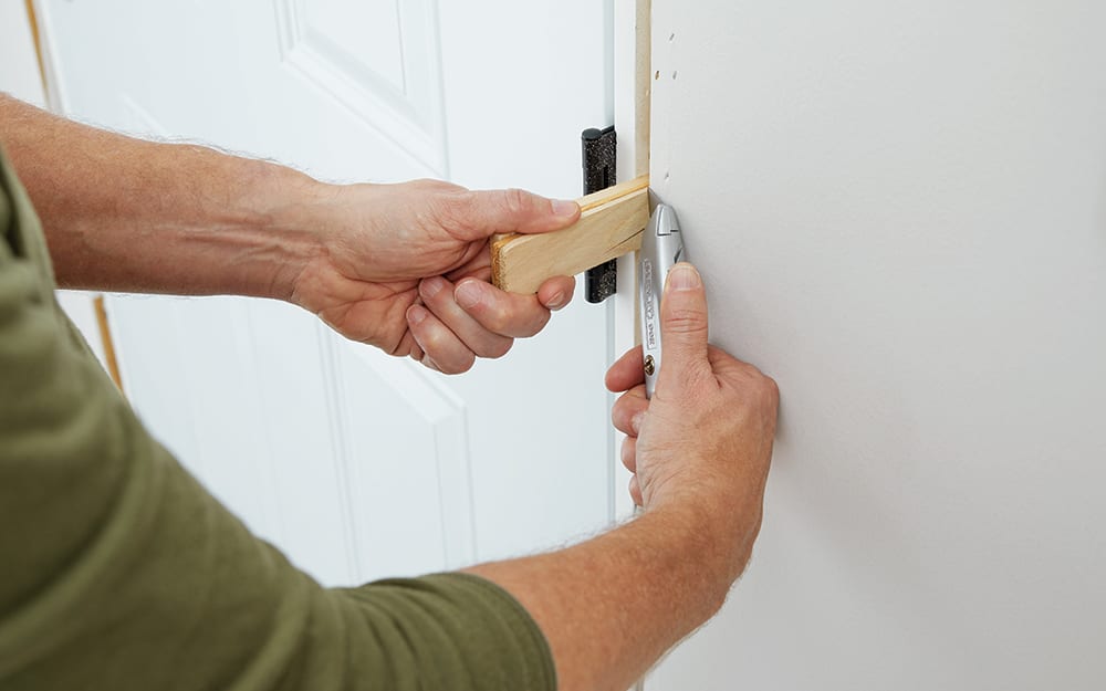 A man anchoring moulding inside the home. A man anchoring moulding inside the home.