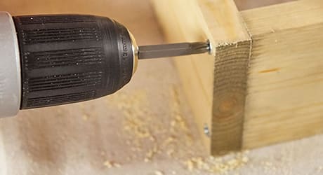 drilling a wood screw into a side and bottom segment to make a corner drilling a wood screw into a side and bottom segment to make a corner