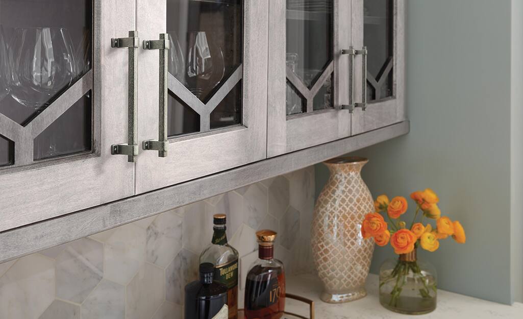 Hardware in a pewter finish installed on grey cabinetry.