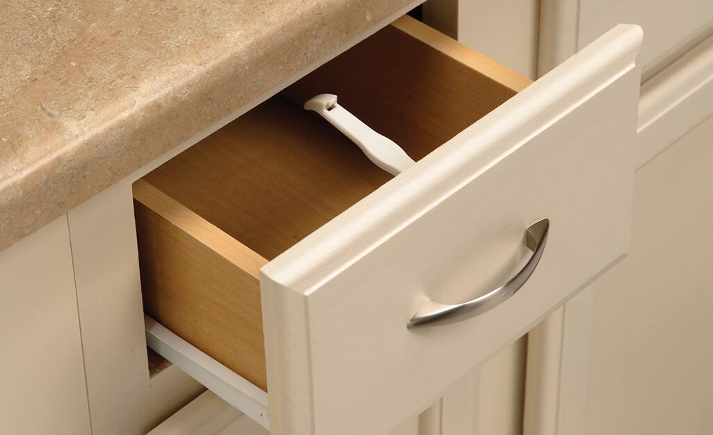 An open kitchen drawer with a latch installed.