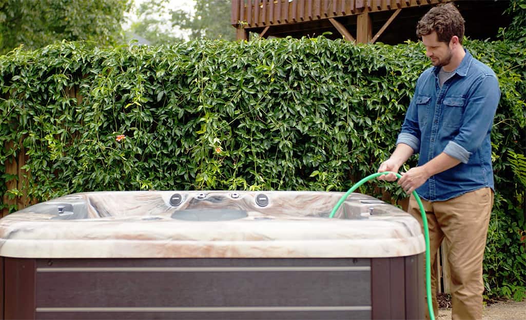 Someone filling a hot tub with water from a hose. Someone filling a hot tub with water from a hose.