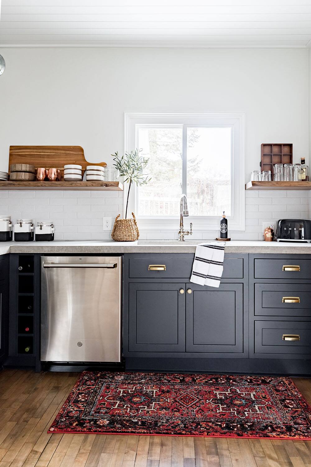 A kitchen sink area with floating wood shelves on either side. A kitchen sink area with floating wood shelves on either side.