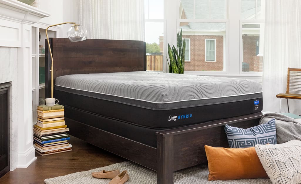 A bedroom with a hybrid mattress on a dark wood bedframe. A bedroom with a hybrid mattress on a dark wood bedframe.