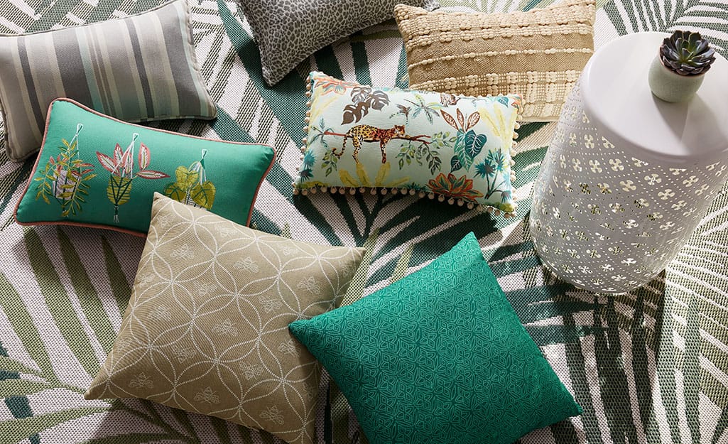 Pillows and other patio accessories on a green and white rug. Pillows and other patio accessories on a green and white rug.