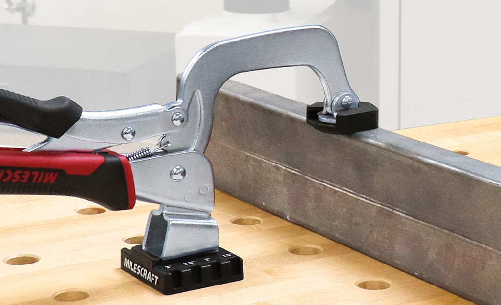 A clamp is used on a piece of metal. A clamp is used on a piece of metal.