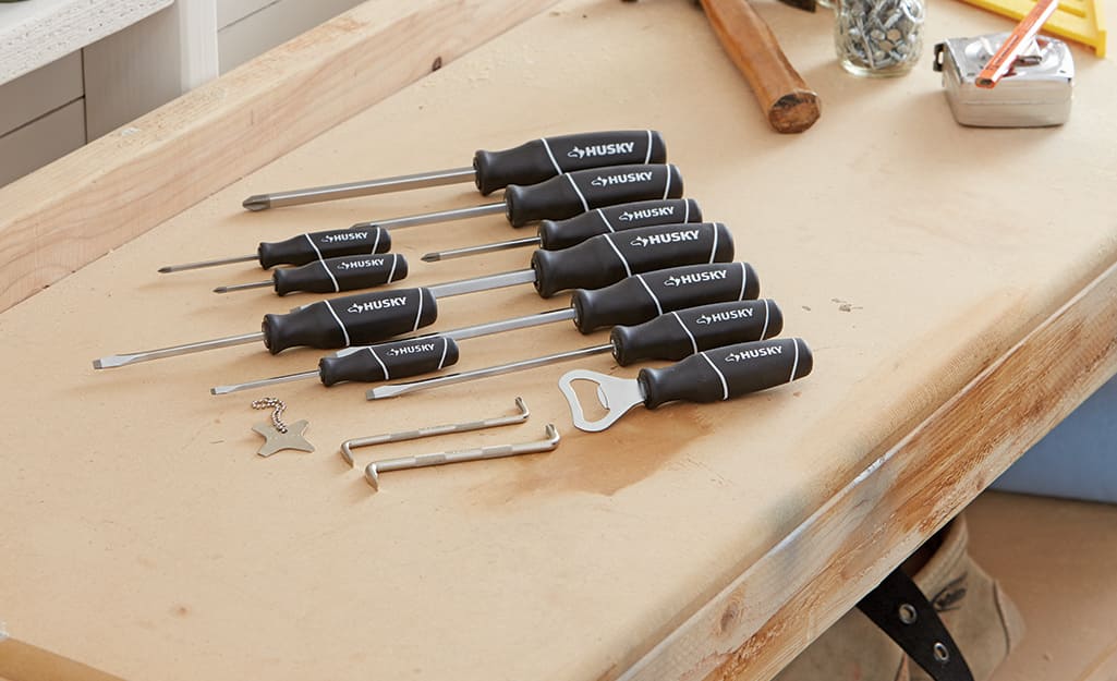 A set of screwdrivers sits on a workbench. A set of screwdrivers sits on a workbench.