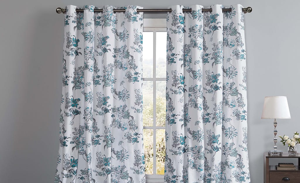 White and blue light-filtering curtains over a window. White and blue light-filtering curtains over a window.