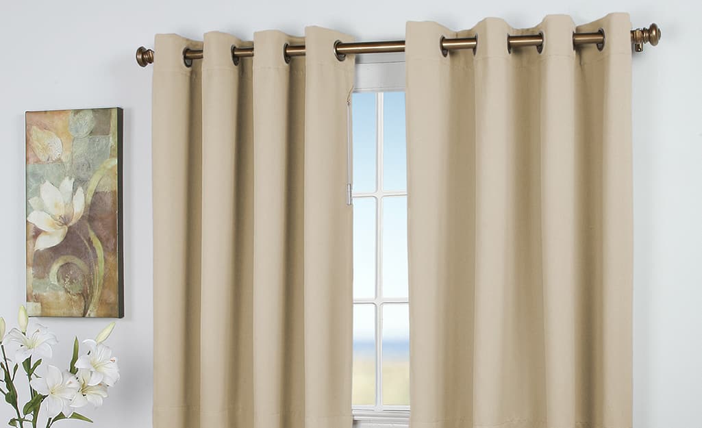 Beige grommet curtains over a window. Beige grommet curtains over a window.