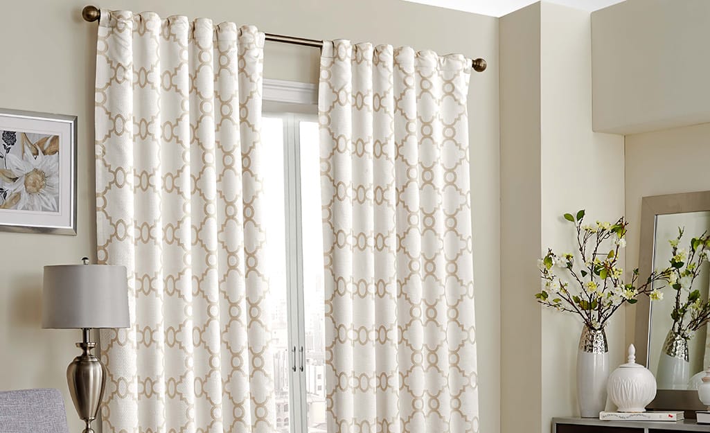 White and gold rod pocket curtains over a window. White and gold rod pocket curtains over a window.