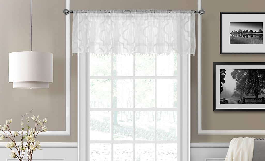 A lacy, white valance over a window. A lacy, white valance over a window.