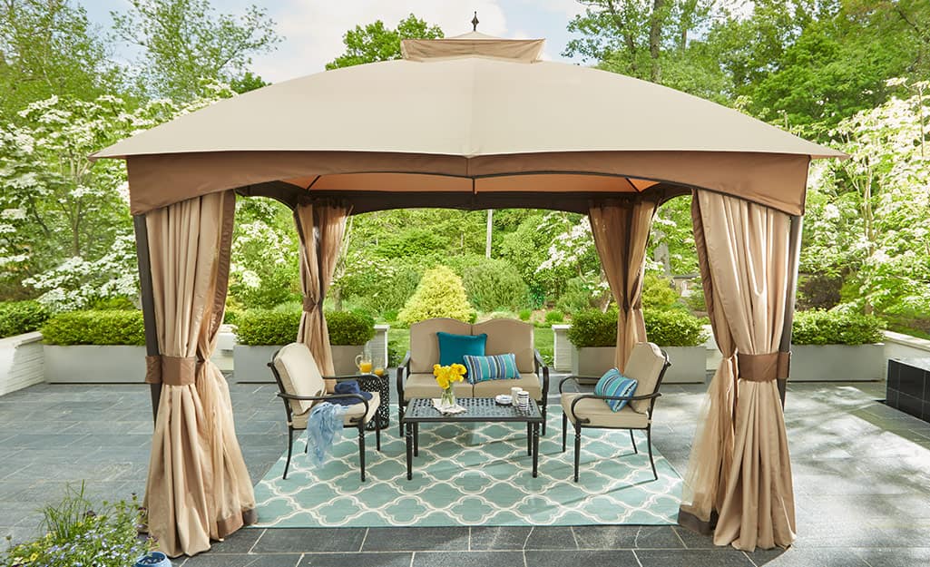Outdoor curtains around an outdoor dining table and chairs. Outdoor curtains around an outdoor dining table and chairs.