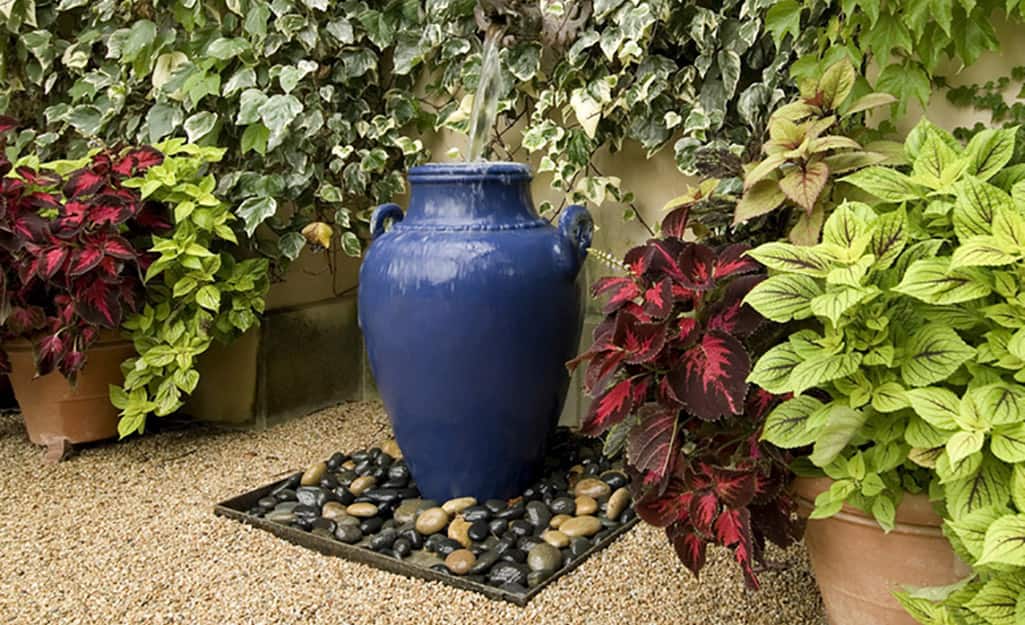 Decorative river rocks surrounding a blue garden urn on a bed of small stone gravel. Decorative river rocks surrounding a blue garden urn on a bed of small stone gravel.