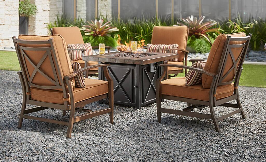 A set of garden furniture on an outdoor gravel surface. A set of garden furniture on an outdoor gravel surface.