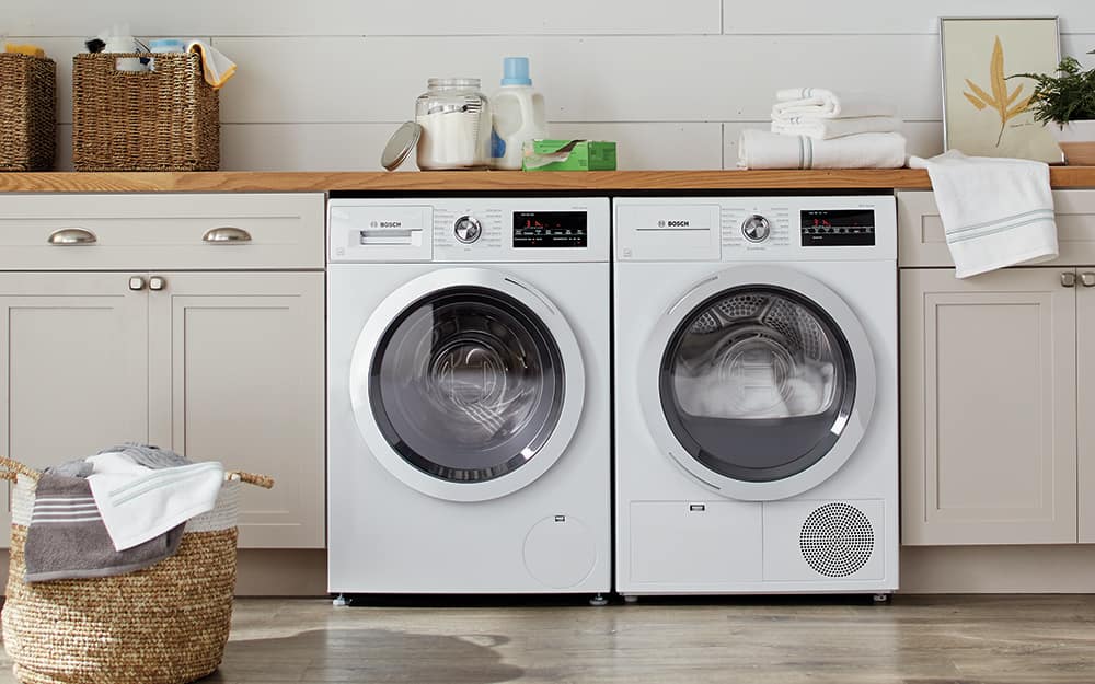A white washer and matching dryer sit next to each other in a laundry room. A white washer and matching dryer sit next to each other in a laundry room.