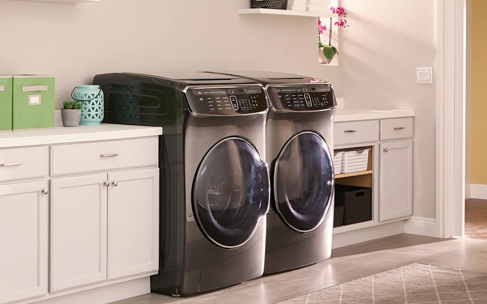 A black front-load washer and gas dryer sit side-by-side in a laundry room. A black front-load washer and gas dryer sit side-by-side in a laundry room.
