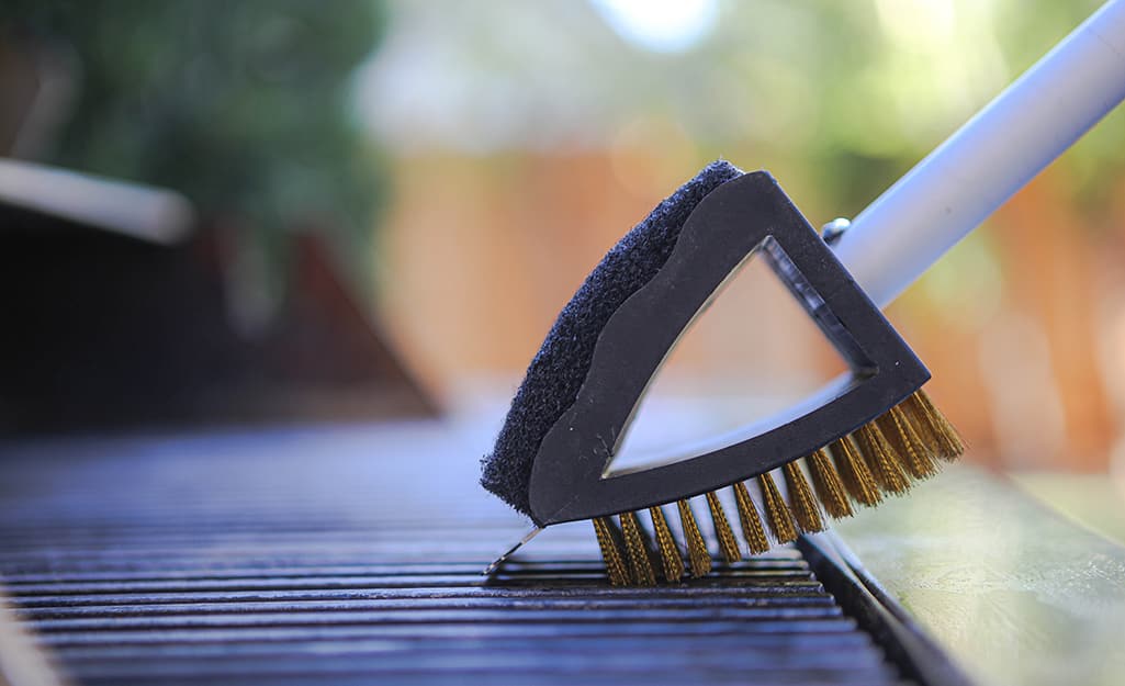 A grill brush is used to clean a grill grate. A grill brush is used to clean a grill grate.
