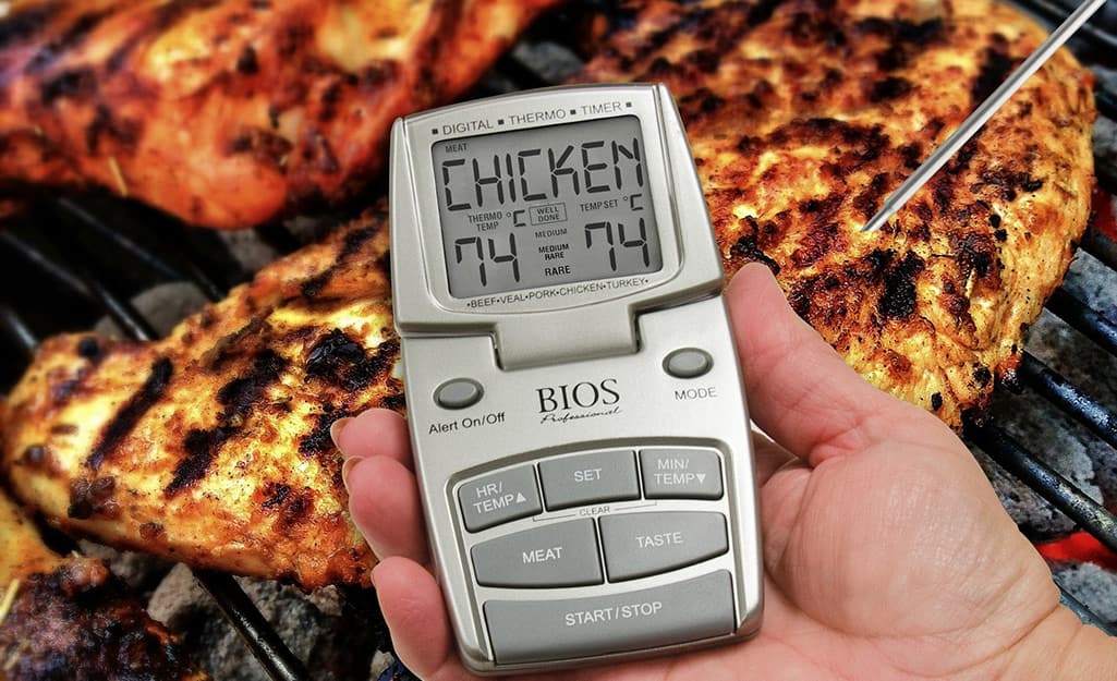 A person uses a wireless meat thermometer to grill. A person uses a wireless meat thermometer to grill.