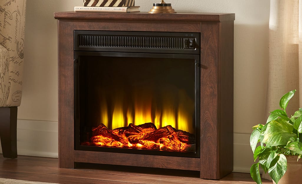 A Hampton Bay fireplace with glowing logs in a living room. A Hampton Bay fireplace with glowing logs in a living room.