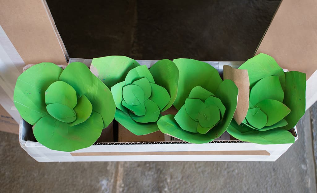 A box of paper flowers with green petals. A box of paper flowers with green petals.