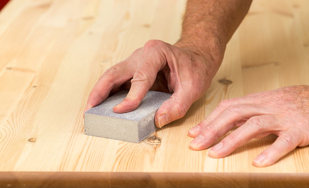Someone sanding a wood board. Someone sanding a wood board.