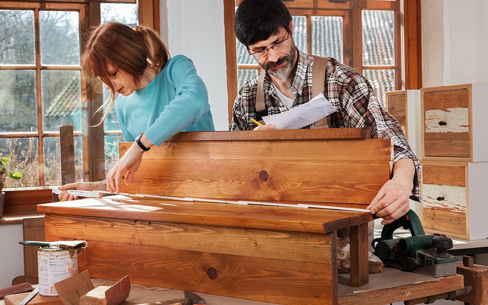 Two people measuring wood to build a staircase. Two people measuring wood to build a staircase.