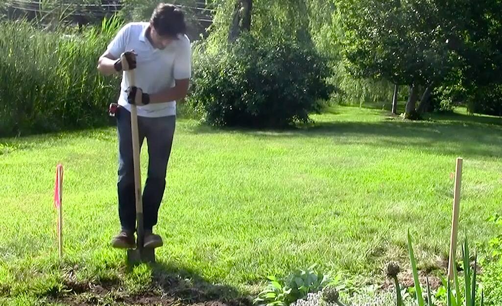 A person using a shovel to dig a trench. A person using a shovel to dig a trench.