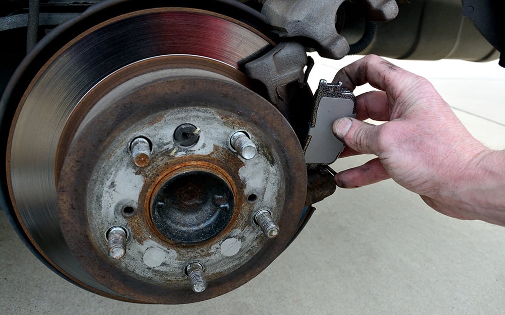 A person removing old brake pads A person removing old brake pads