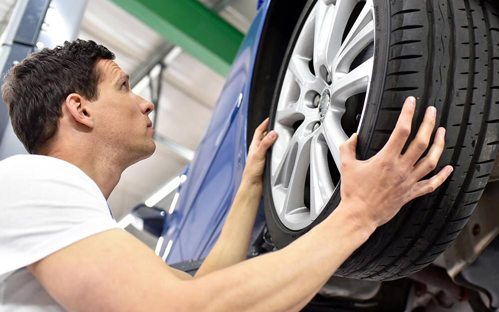 A man installing a tire on a car A man installing a tire on a car