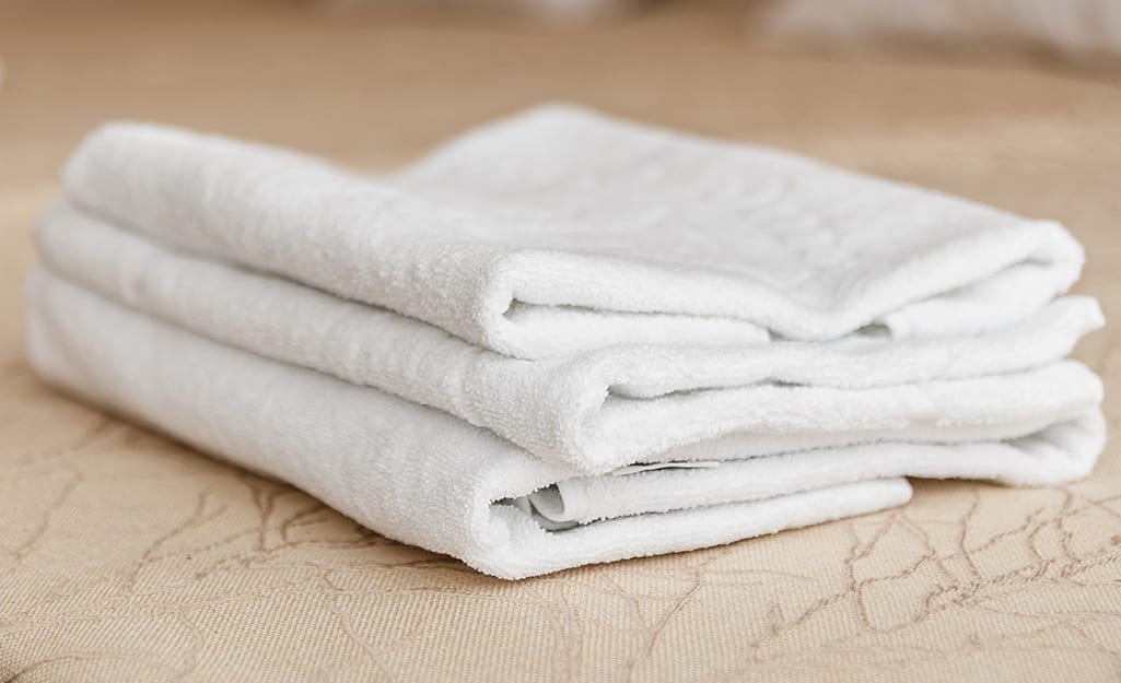 A folded white pillowcase on top of a table. A folded white pillowcase on top of a table.