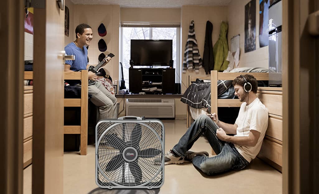 Two men in a room with a box fan. Two men in a room with a box fan.