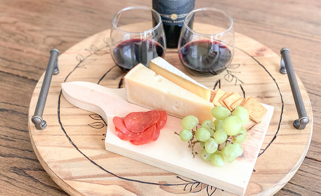 A finished Lazy Susan holds wine, cheese, fruit and meat. A finished Lazy Susan holds wine, cheese, fruit and meat.