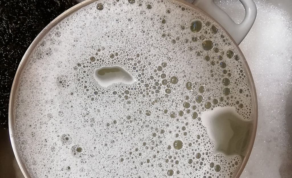 A turkey fryer pot filled with soapy water. A turkey fryer pot filled with soapy water.