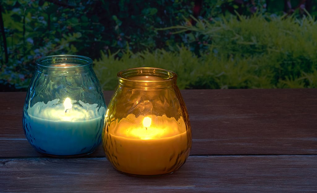 Candles on a wood table in a backyard. Candles on a wood table in a backyard.