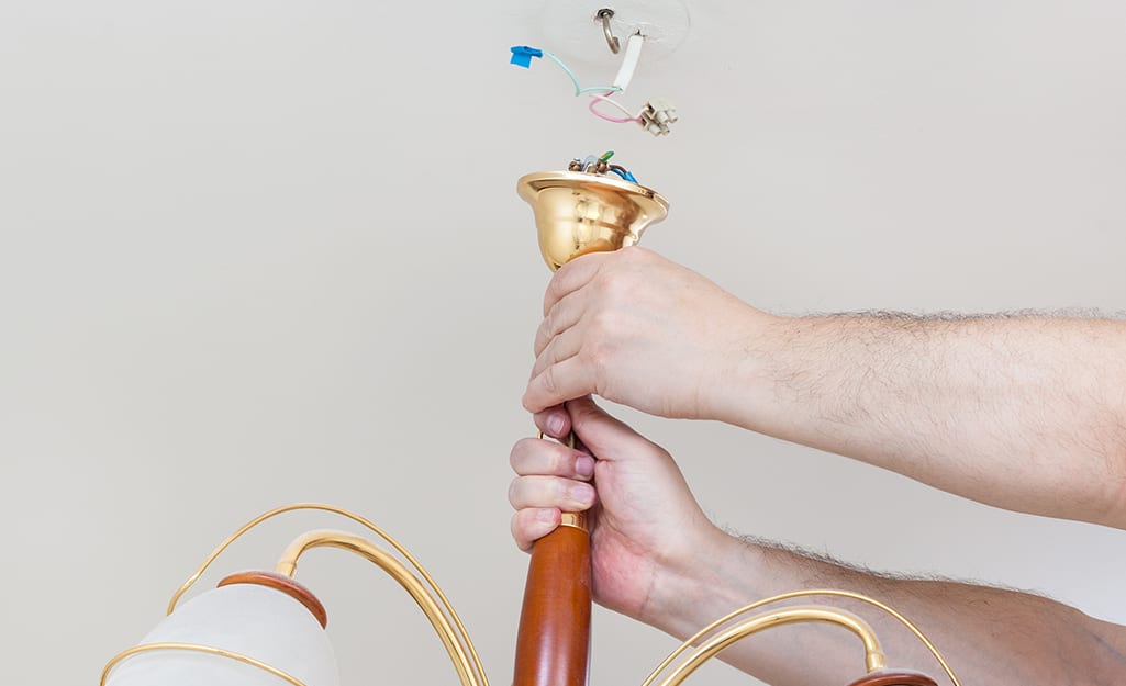 Someone removing old light fixture. Someone removing old light fixture.