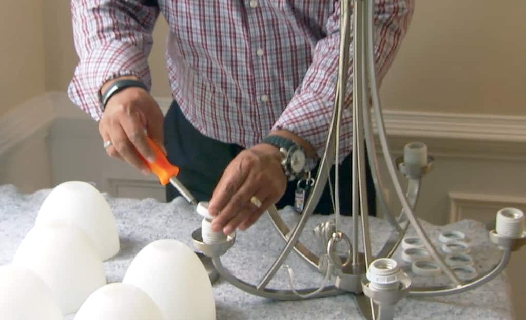 Someone assembling a chandelier. Someone assembling a chandelier.