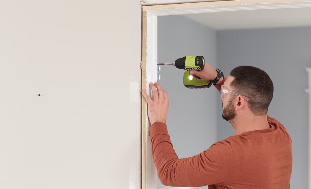 A man removes the old door and frame. A man removes the old door and frame.