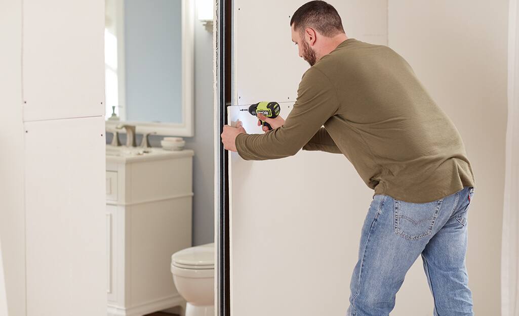 A man repairs the drywall. A man repairs the drywall.