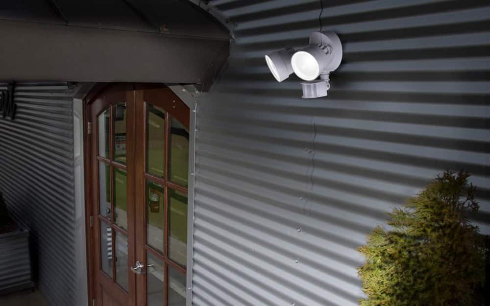 a set of flood lights on the exterior of a home near the front door a set of flood lights on the exterior of a home near the front door