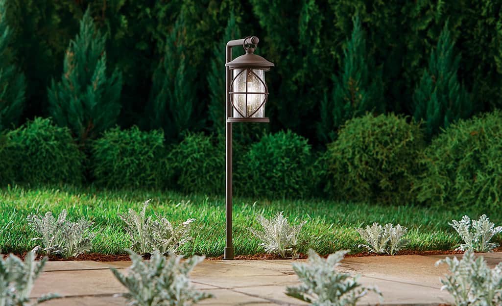 A lantern style low voltage landscape light installed next to a walkway. A lantern style low voltage landscape light installed next to a walkway.