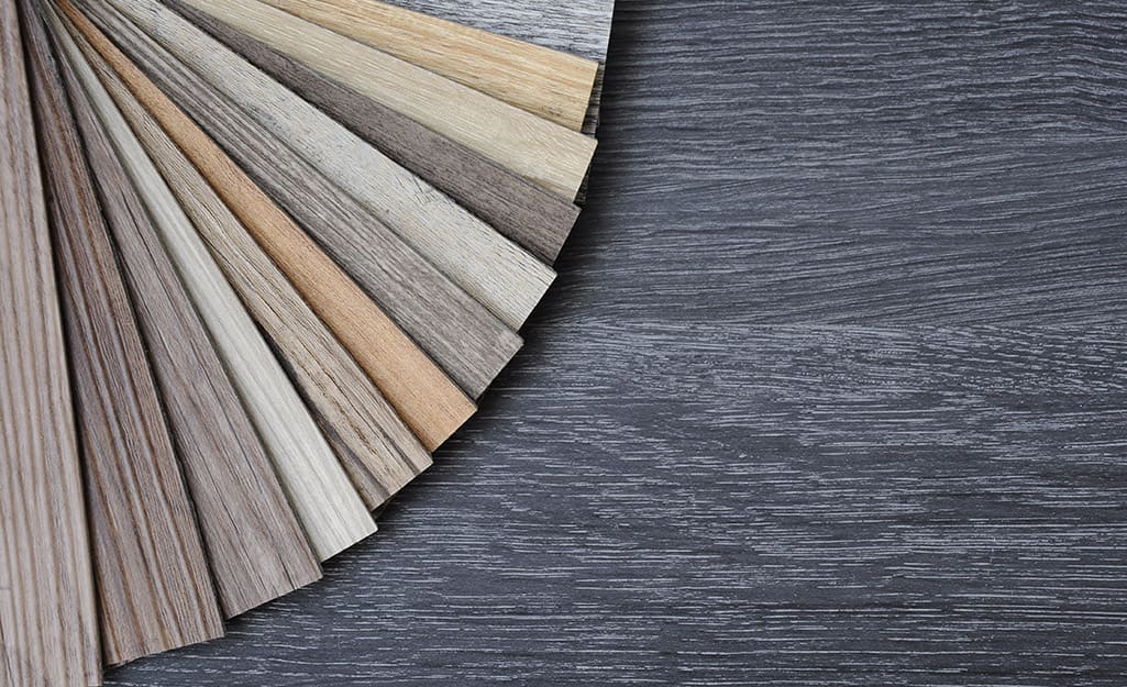 Different swatches of luxury vinyl plank flooring are fanned out over a vinyl floor. Different swatches of luxury vinyl plank flooring are fanned out over a vinyl floor.