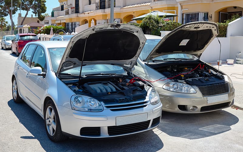 two cars side by side with each front hood open two cars side by side with each front hood open