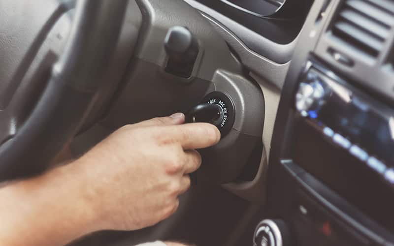 person turning the key in the ignition of a car person turning the key in the ignition of a car