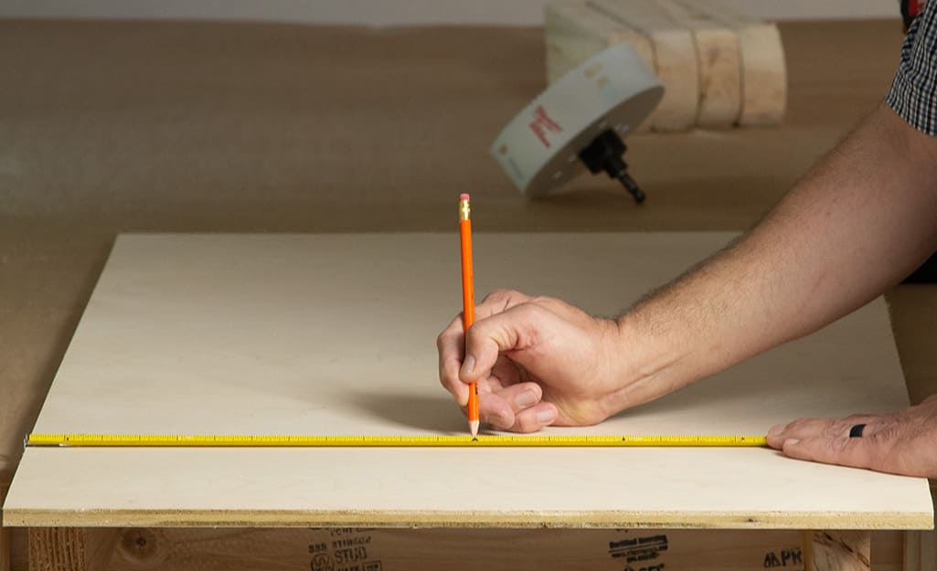 A plywood board being measured for a cornhole top. A plywood board being measured for a cornhole top.