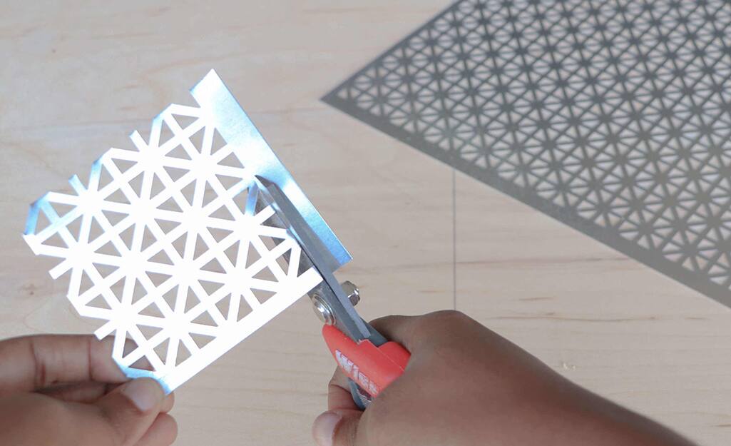 Metal snowflakes are cut out using snips. Metal snowflakes are cut out using snips.