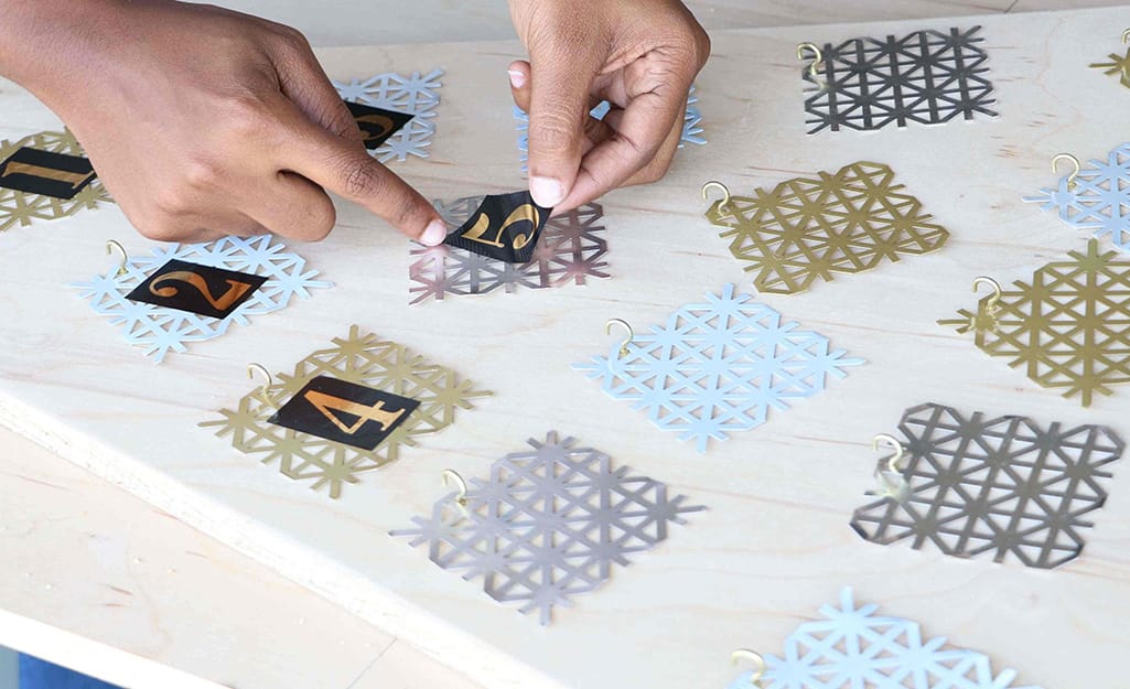 Adhesive numbers are added to metal snowflakes. Adhesive numbers are added to metal snowflakes.
