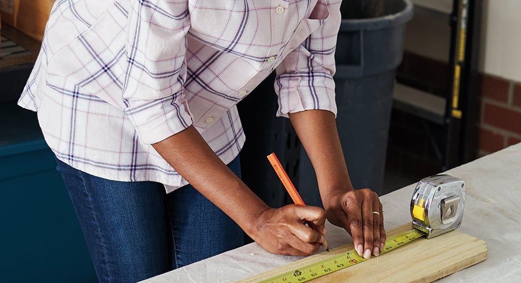 A person making measuring marks on a piece of wood. A person making measuring marks on a piece of wood.